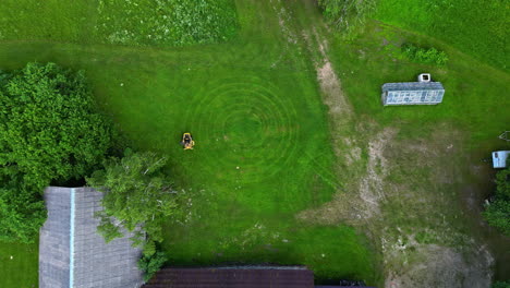 Cutting-grass-on-a-riding-mower-in-a-circular-or-bull's-eye-pattern---straight-down-aerial-time-lapse