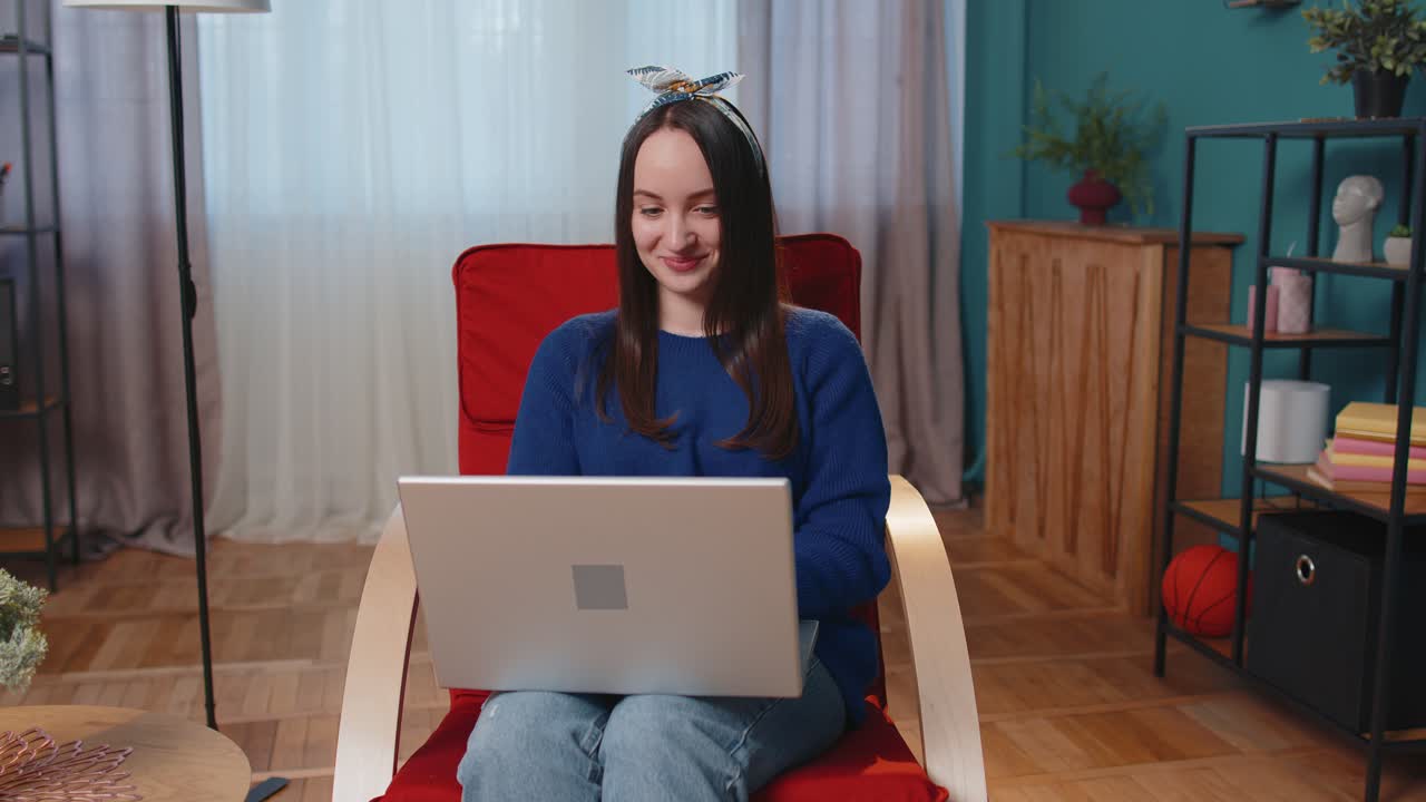 젊은 성인 여성은 집 사무실에서 노트북 pc를 사용하고 타이핑하고 브라우징하고 와우, 네, 위대한 큰 승리를 발견했습니다.