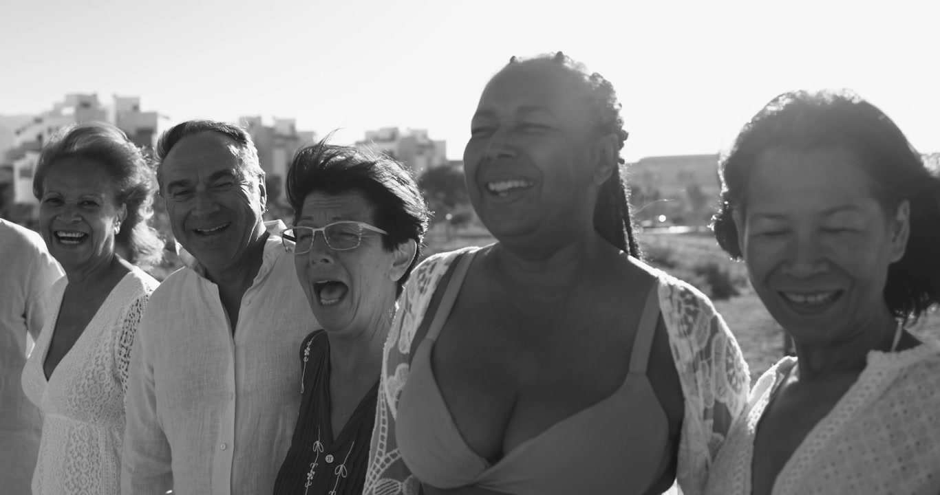 Groupe de seniors divers et heureux souriant et riant en extérieur
