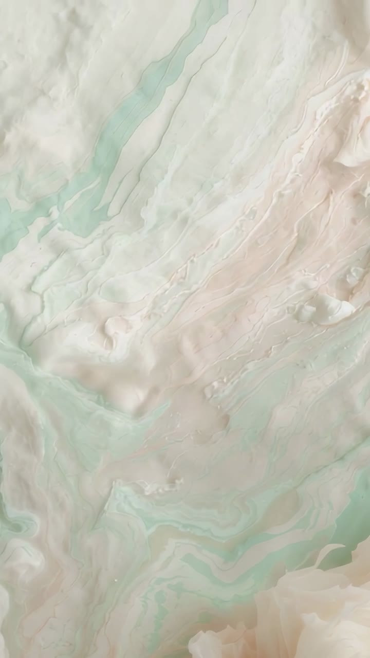 Vertical video: Panning camera revealing glossy onyx slab in studio with mint veins and beige bands