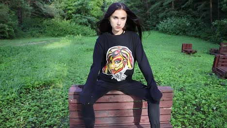 attractive young woman sitting down in a forest environment