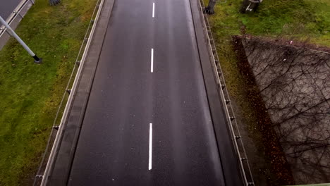 Weißes-Luxusauto,-Das-Tagsüber-An-Einer-Asphaltstraße-In-Der-Nähe-Der-Landschaft-Vorbeifuhr