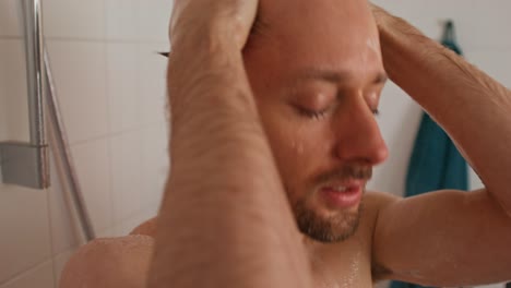 hombre lavándose el cabello en una ducha