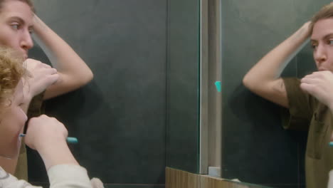 mother teaching son how to brush teeth in bathroom