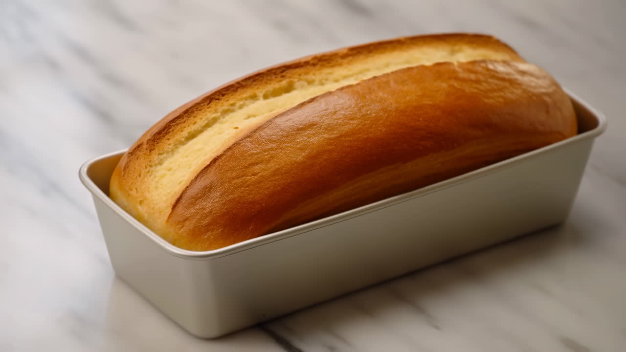 Golden Brioche Loaf In Metal Pan Marble Countertop, Glossy Buttery Crust With Even Rise, Home Baker Cooling