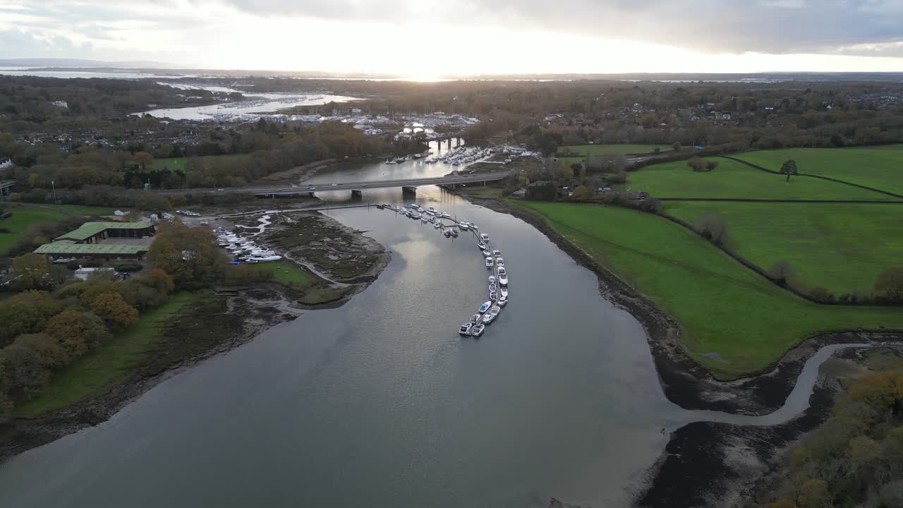 Drone video of the serene River Hamble at Manor Farm Country Park, Hampshire, England. Captures stunning autumn landscapes with winding river, vibrant fields, and distant towns as seen from above