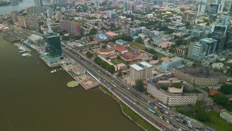 Traffic-and-cityscape-of-Falomo-Bridge,-Lagos-Law-school-and-the-Civic-centre-tower-in-Lagos-Nigeria