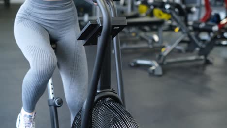 active woman spinning air bike in gym brunette female training on air bike in slow motion f active woman spinning air bike in gym brunette female training on air bike in slow motion fitness girl working in gym