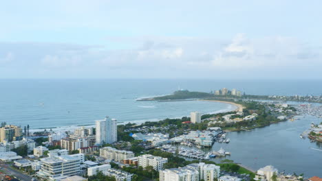 aerial drone above mooloolaba beach shore with seaside town and blue ocean views at dusk, 4k