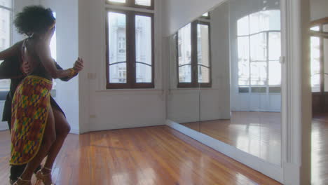 professional ballroom dancers dancing tango in sunlit studio