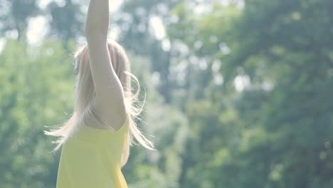 woman in yellow dress dancing gracefully in summer park