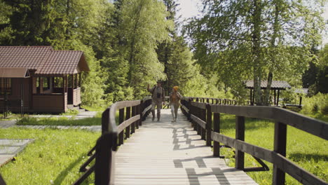 couple hiking on a wooden path through the forest