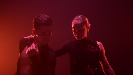 ballroom dancers looking camera indoors. sensual couple dancing inside.