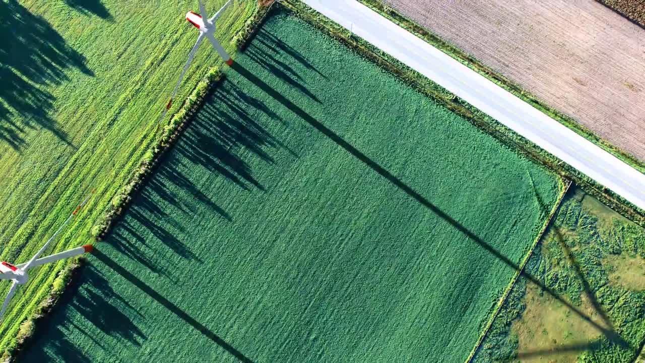 Metraje dinámico de modernas turbinas eólicas girando con gracia contra un cielo despejado, simbolizando el poder de la energía renovable