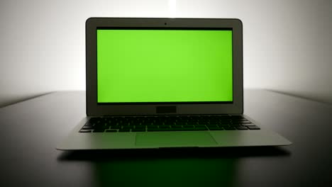 portátil de negocios con pantalla verde monitor de clave croma y fondo de paisaje urbano.