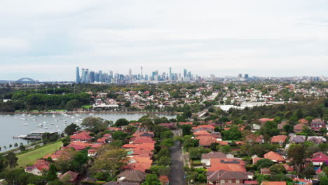 disparo aéreo de avión no tripulado volando hacia el cbd de sídney sobre casas residenciales del centro-oeste en sídney, australia