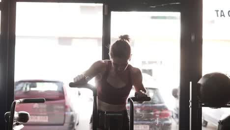 mujer trabajando en una bicicleta de ejercicio en un gimnasio