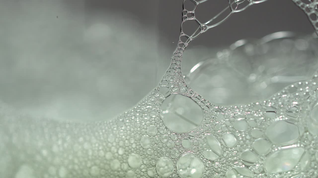 매크로 비누 거품은 프레임 전체에서 더 짧은 빛 스윕으로 극단적으로 닫힙니다.