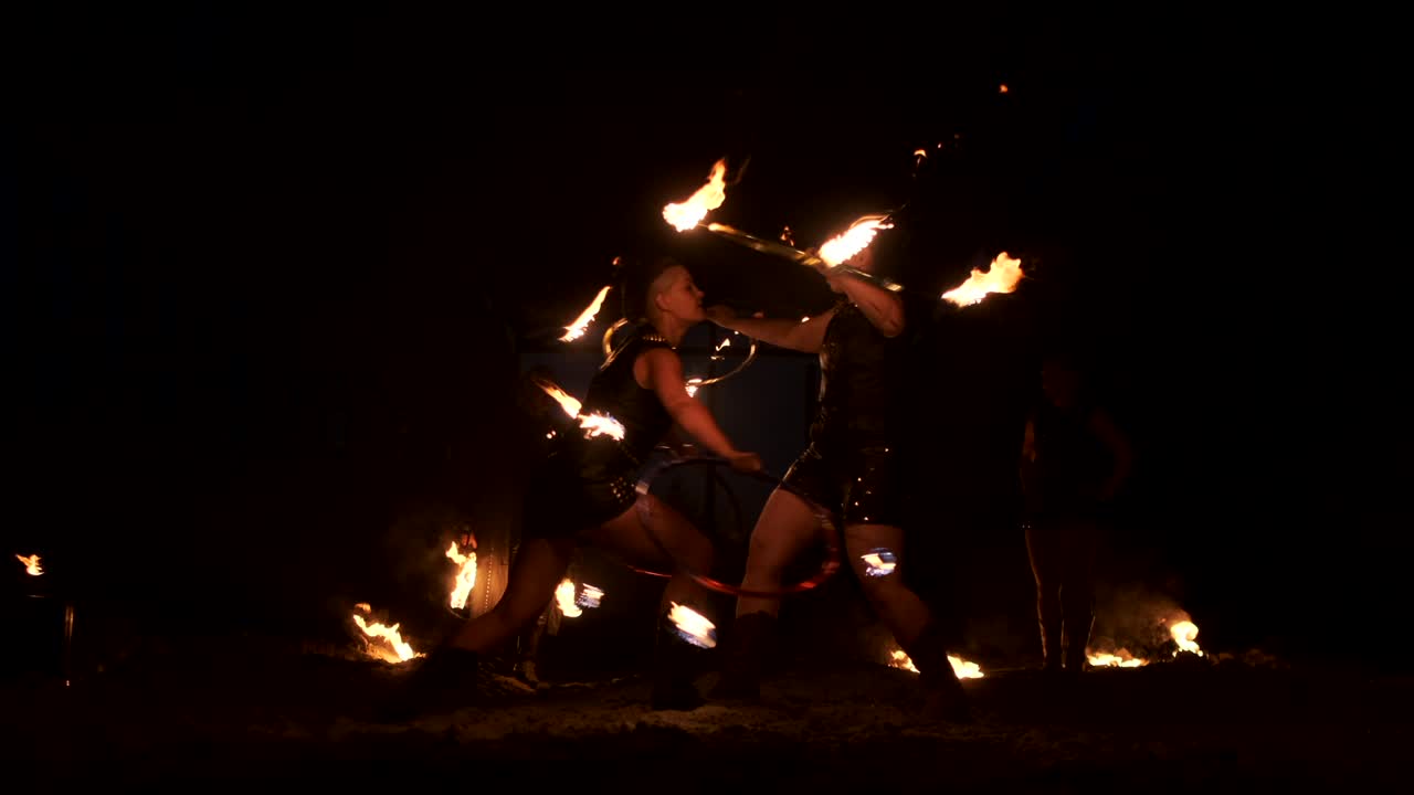 Slow motion: Professional fire performance three women with torches and a man with flamethrowers