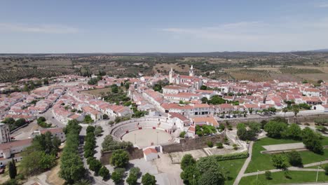 Vista-Aérea-Del-Pueblo-Blanco-De-Arronches-En-Portugal,-La-Plaza-De-Toros-Y-La-Iglesia-En-La-Cima-De-La-Colina