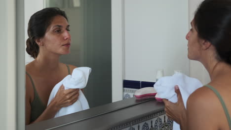 woman drying face in bathroom