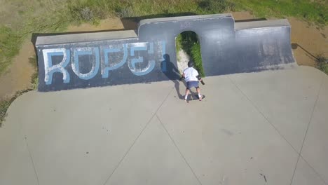 siguiendo a un joven patinando en un parque de patinaje al aire libre