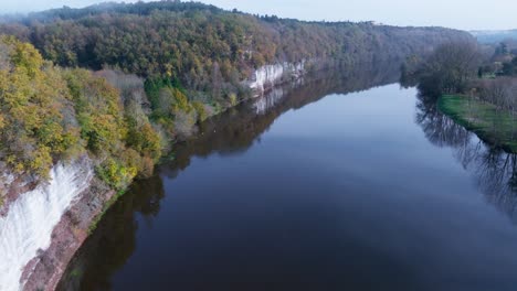 Aerial-view-very-close-to-the-water-along-a-beautiful-cliff,-Bac-De-Sors,-Dordogne-River-in-France