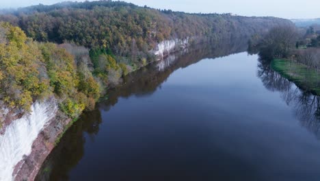 aerial view very close to the water along a beautiful cliff, bac de sors, dordogne river in france