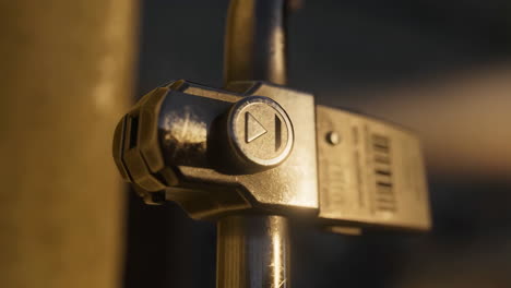 close-up of a metallic device with play/fast forward button on a pole