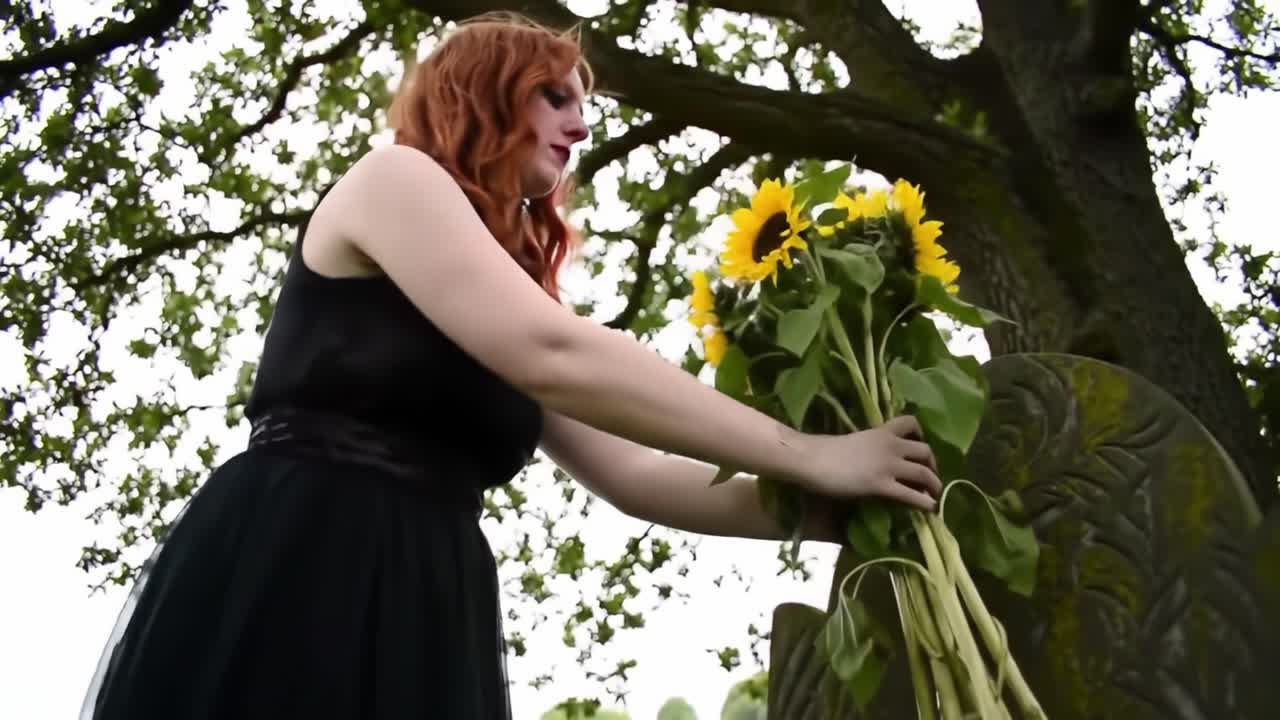 A Solemn Tribute: A Person Laying Sunflowers at a Grave, Signifying Remembrance and Honor in Nature's Embrace Amidst a Serene Landscape