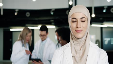 close-up view of arabic female doctor wearing hijab and looking at camera standing in hospital