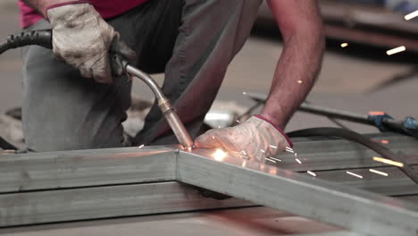 man welding large pieces of metal together using precise techniques - slow motion close-up shot