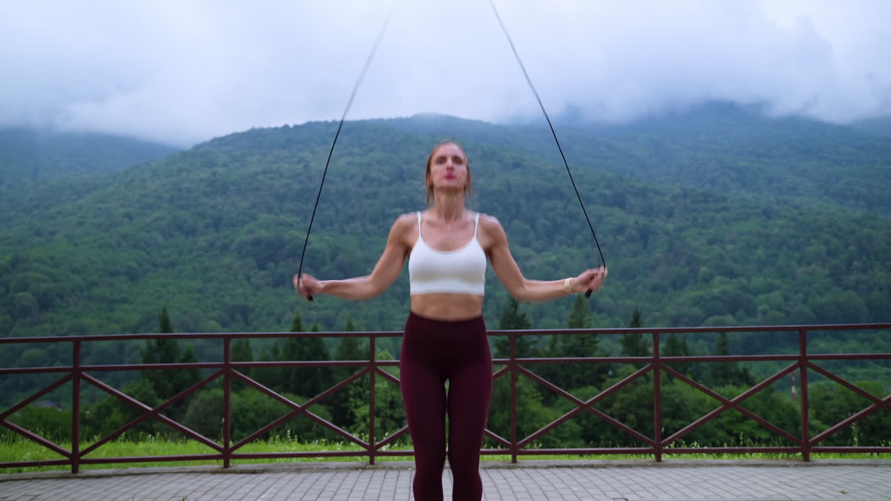 mujer saltando la cuerda en las montañas