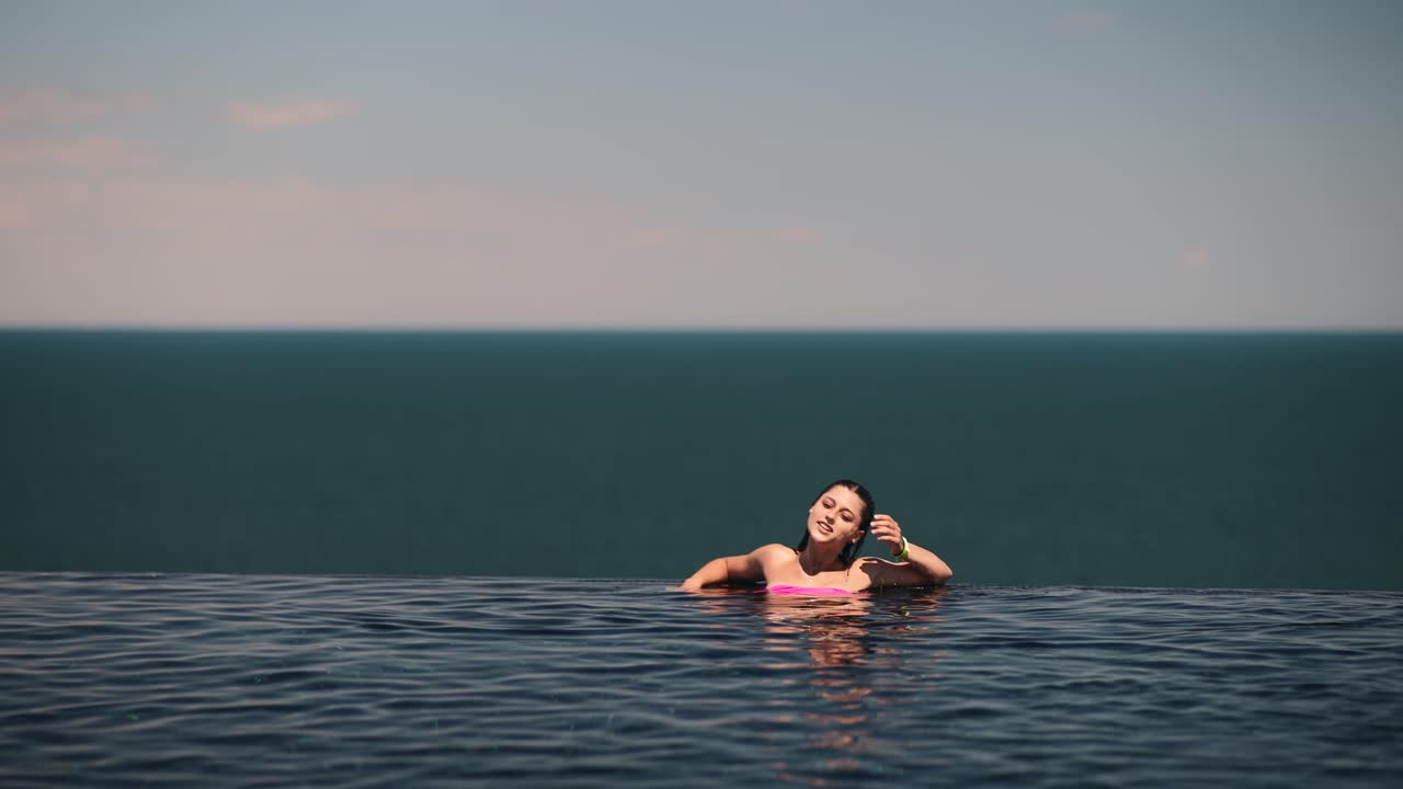 바다를 바라보는 수영장에서 휴식을 취하는 여자