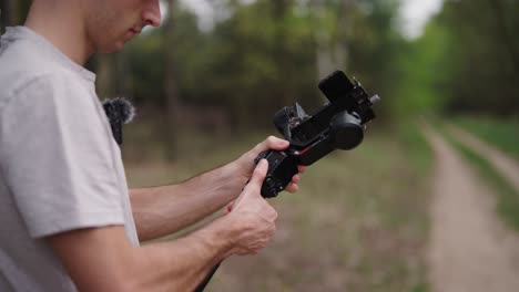 caucasian cameraman attach high capacity battery grip on gimbal stabilizer