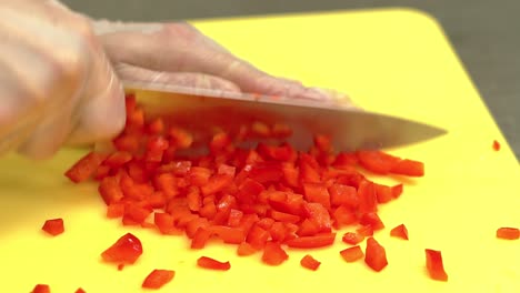 cu cocinera en cámara lenta muy rápidamente corta pimientos búlgaros frescos