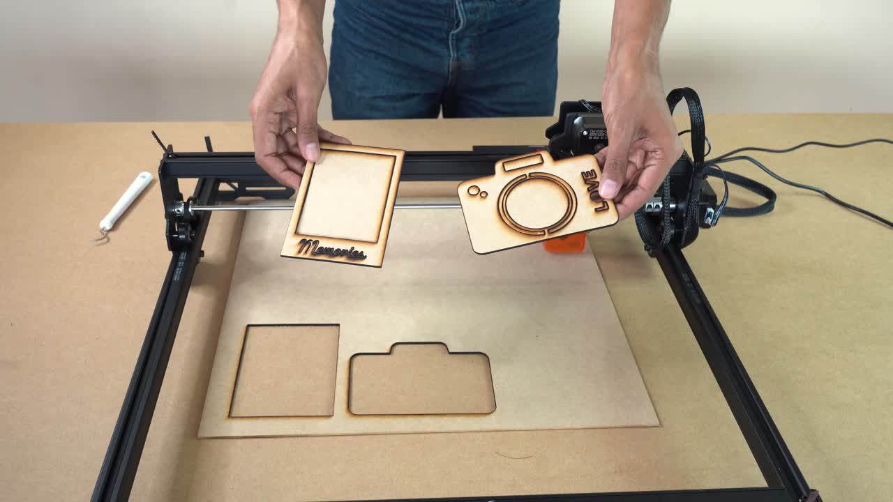 Finished CNC laser-cut plywood parts presented to camera, emphasizing manufacturing output and cut quality