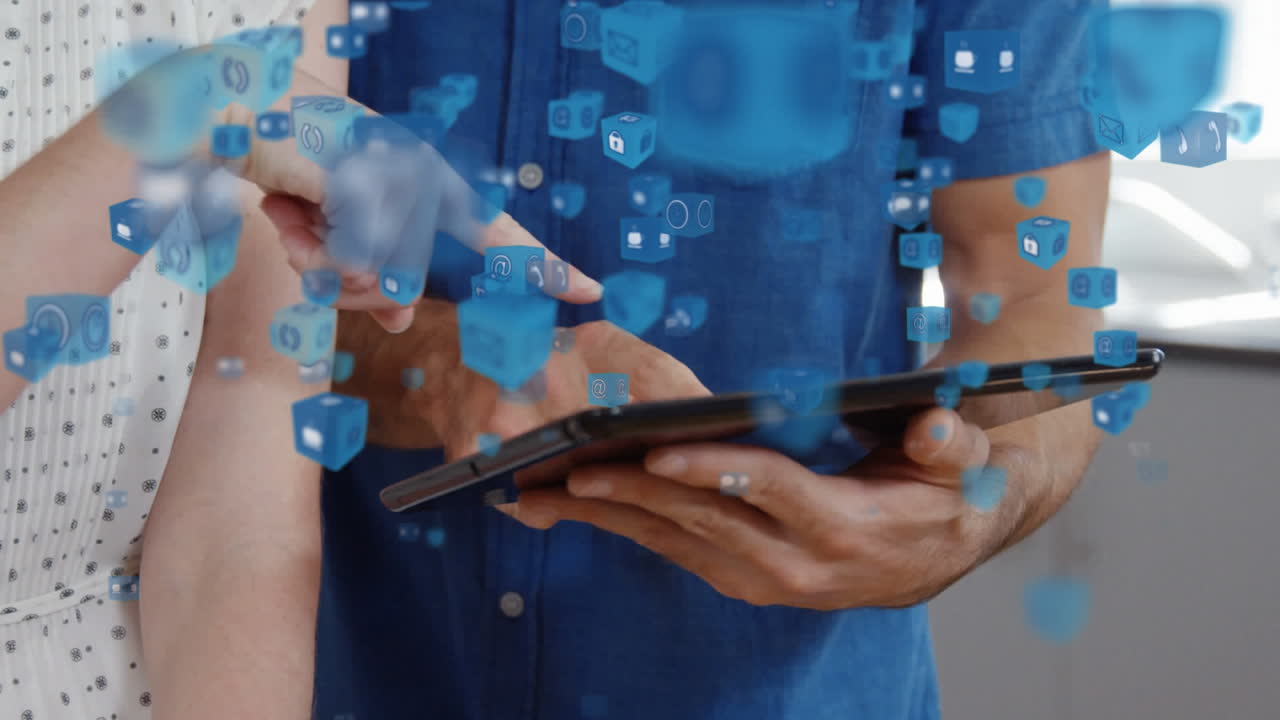 múltiples iconos digitales flotando contra colegas de oficina discutiendo sobre una tableta digital