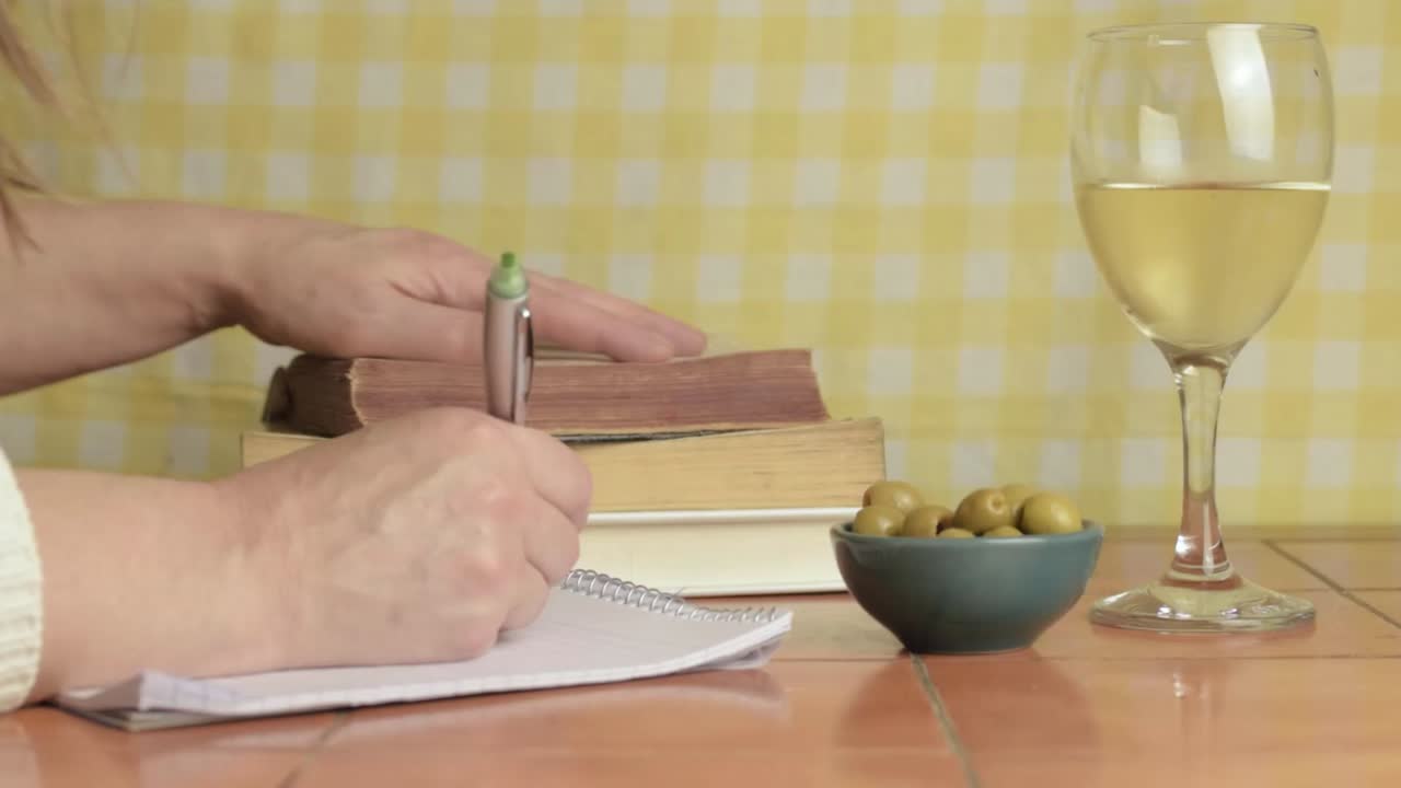 Studying with glass of white wine and olives medium shot