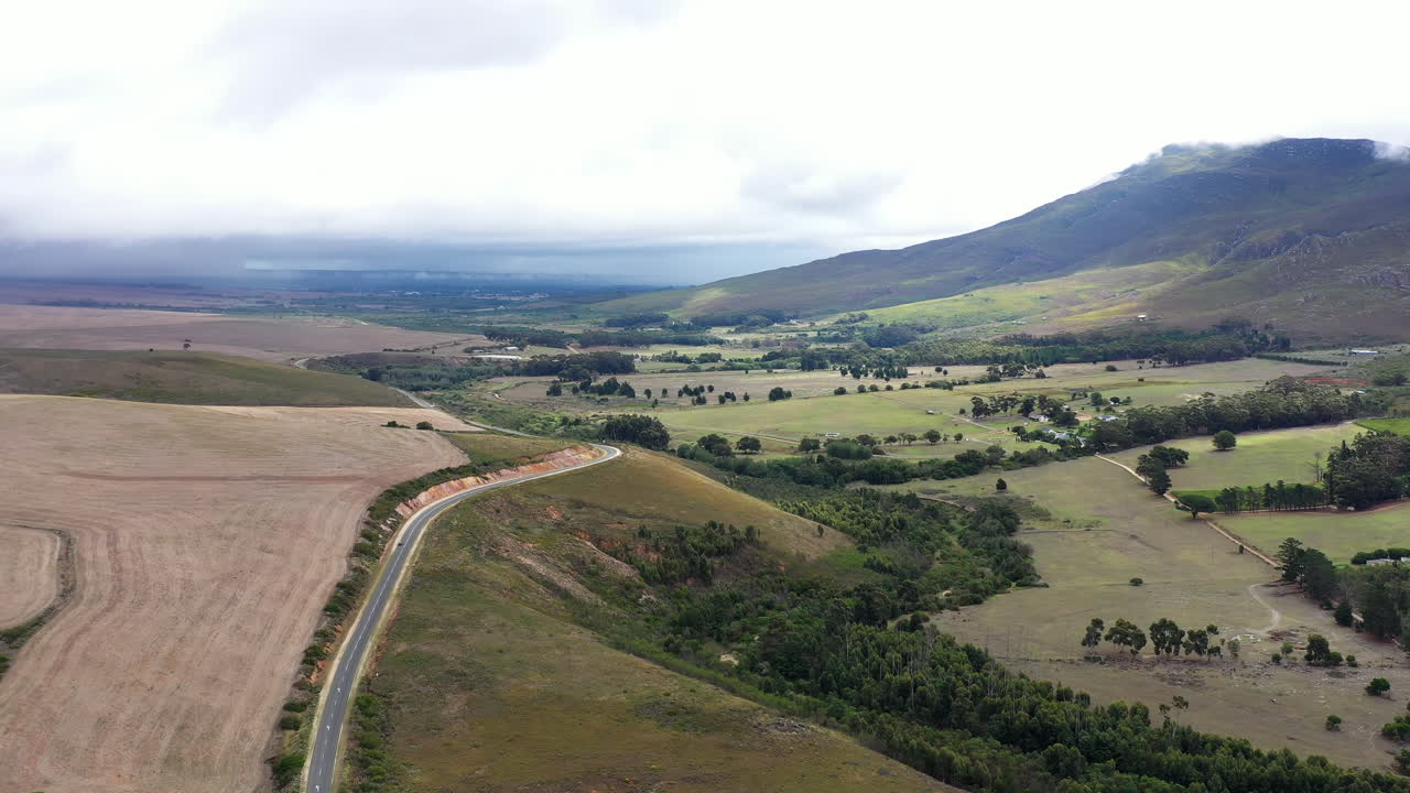paisaje rural sudafricano con campos árboles y montañas