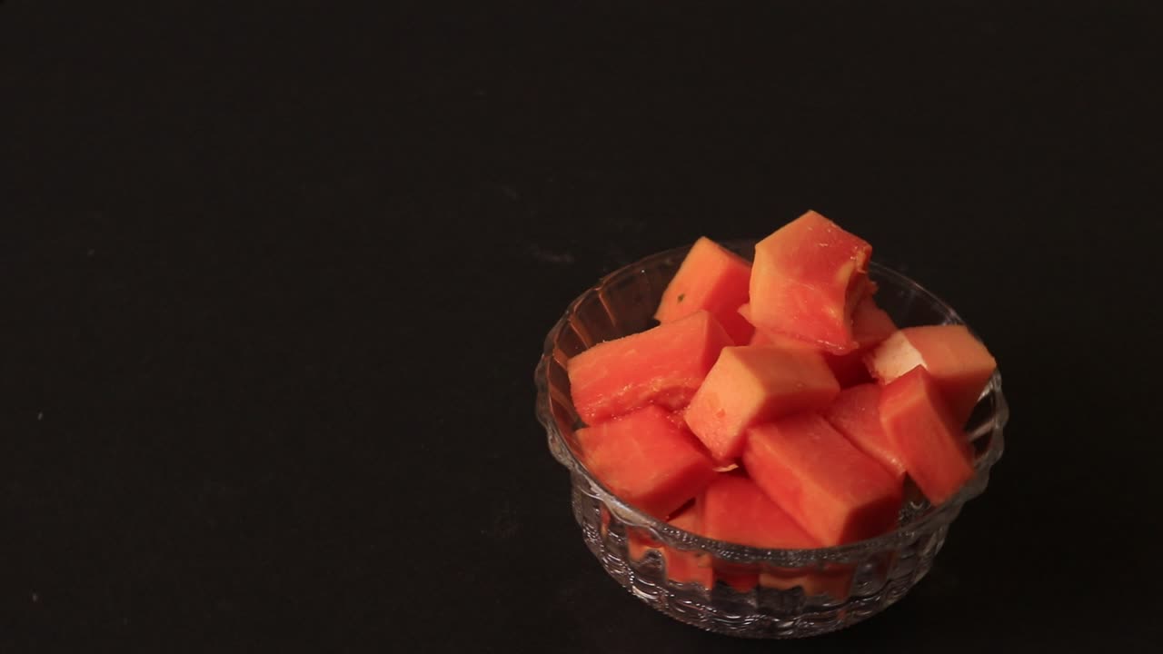 papaya fresca en rodajas sobre fondo negro en la mesa
