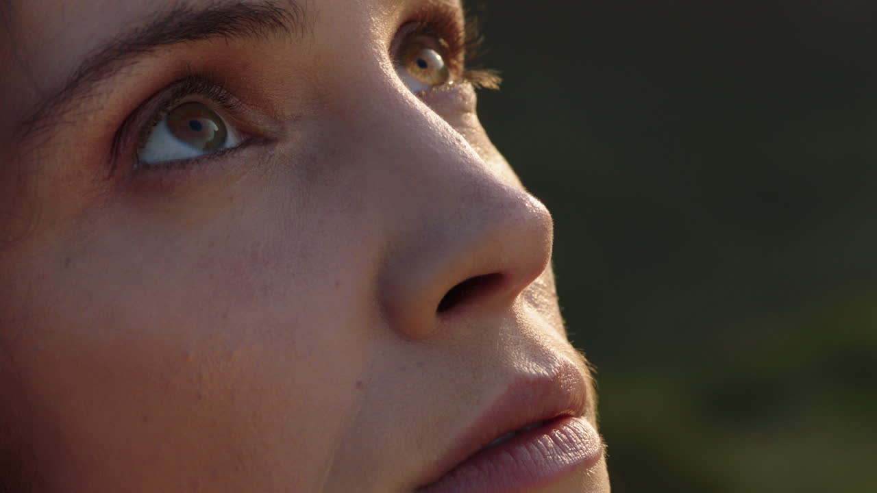retrato en primer plano de una mujer hermosa disfrutando de una tranquila puesta de sol explorando la espiritualidad mirando hacia arriba orando contemplando el viaje con el viento soplando el cabello