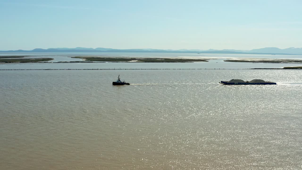 Aerial of Ship Towing Sand in Murky Waters within the Coast
