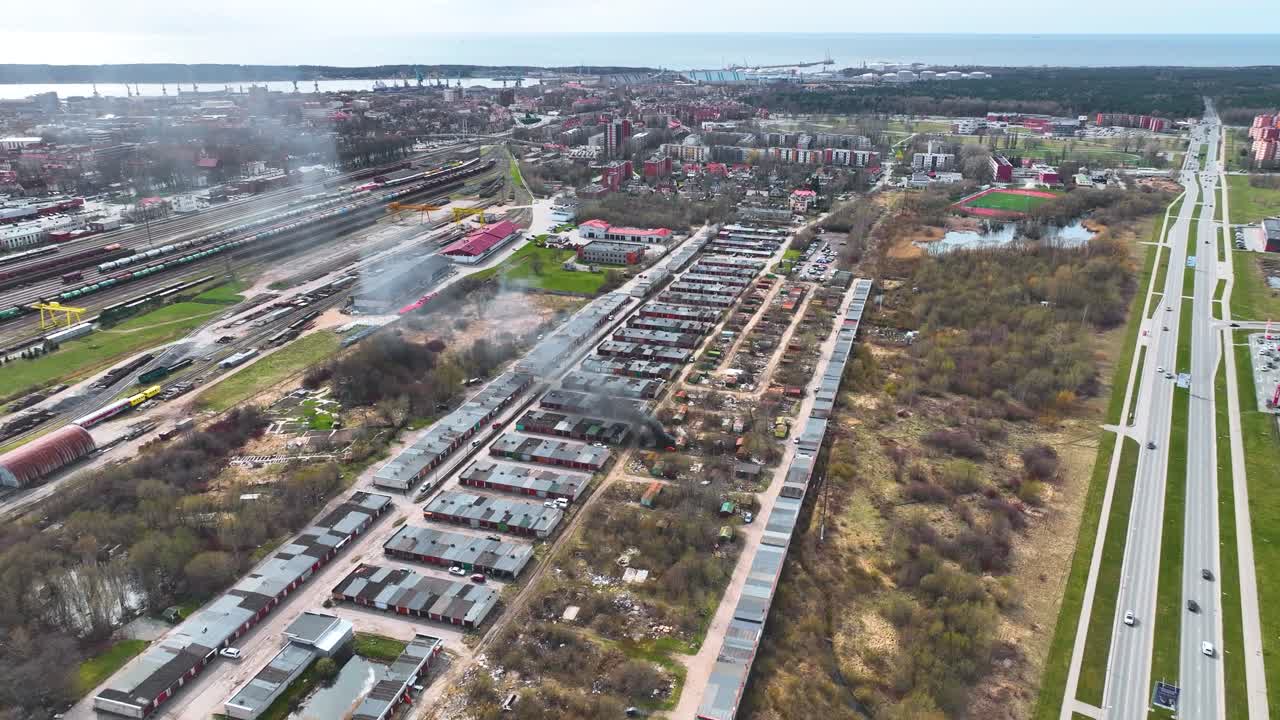 Aerial view, old pile of tires catches fire in a private garage area in the city center
