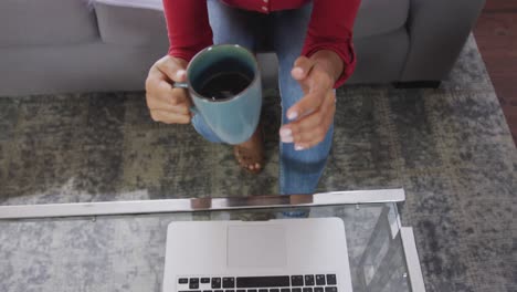 mujer de raza mixta disfrutando de beber té. distanciamiento social y aislamiento en cuarentena