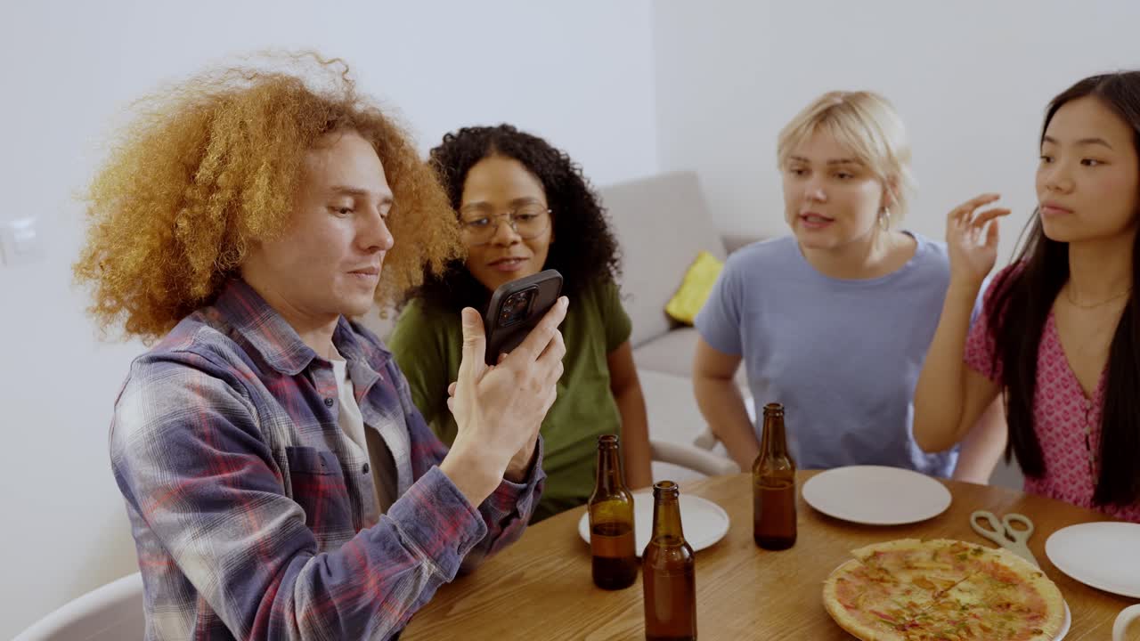 Přátelé si společně užívají pizzu a pivo