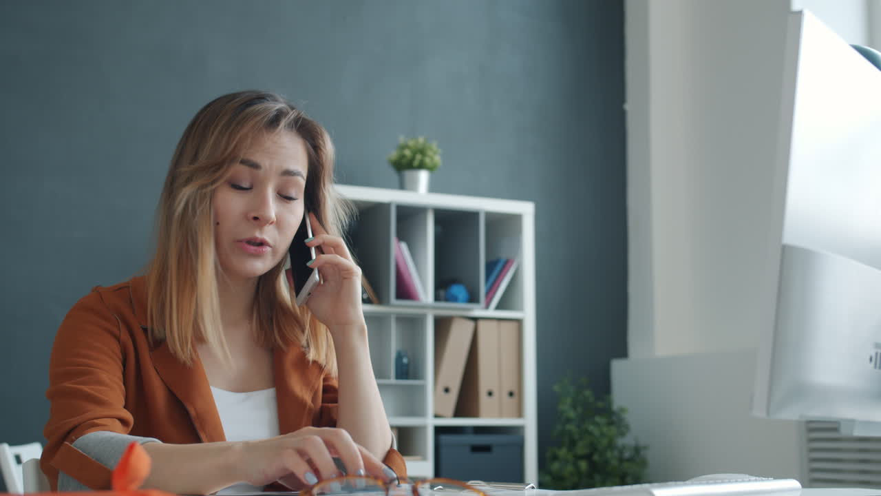 Woman experiencing a problem during phone call | วิดีโอสต็อกแบบ พรีเมี่ยม