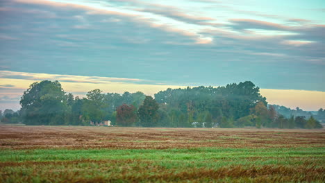 Time-lapse-of-morning-fog-flying-over-agricultural-field-in-nature