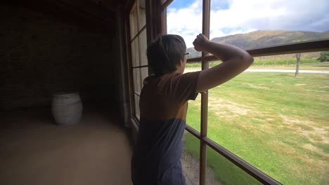 boy looking out of barn window