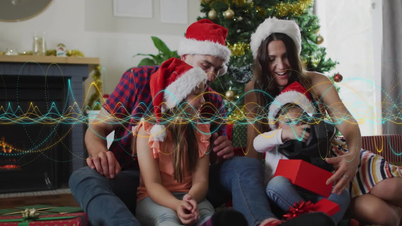 Family sitting on sofa Xmas morning, woman guiding child opening red gift while waveform sweeping